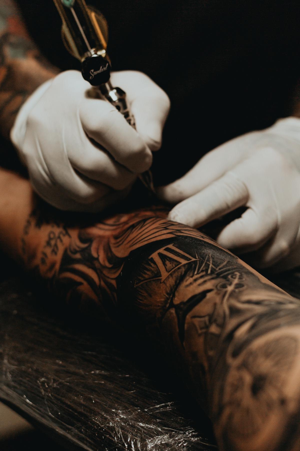 A close-up image of a dragon tattoo on a person's arm, showcasing intricate details of line work, shading, and color.