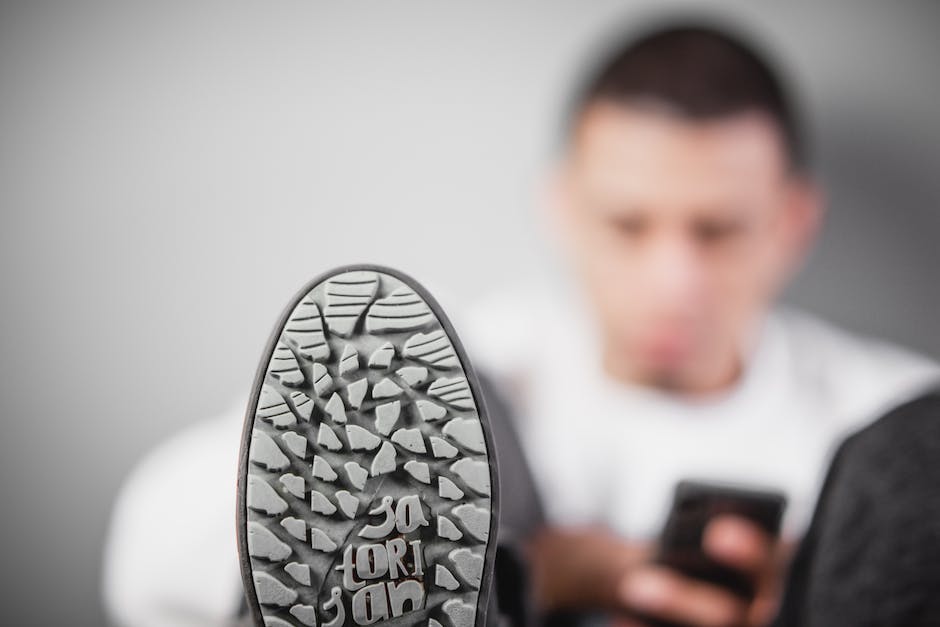 A man wearing slip-on shoes looking at a timeline of footwear with ancient Egyptian and Roman-inspired sandals on one end and modern slip-on shoes on the other end.